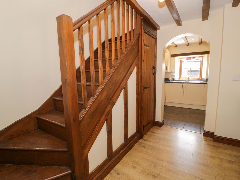 A hallway leading to a kitchen with stairs at Bwthyn Y Wennol near Dolwen Abergele