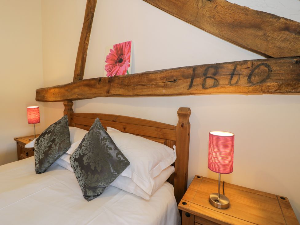 A bedroom with a bed and bedside tables at Bwthyn Y Wennol Dolwen near Abergele