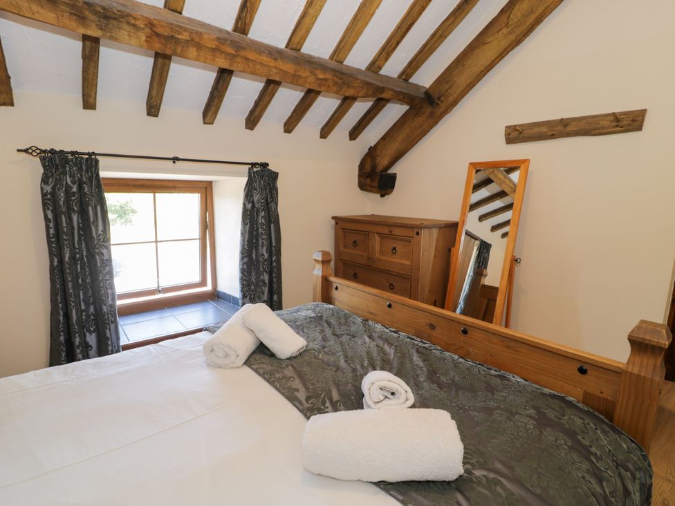 A bedroom with a bed and window at Bwthyn Y Wennol in Dolwen near Abergele