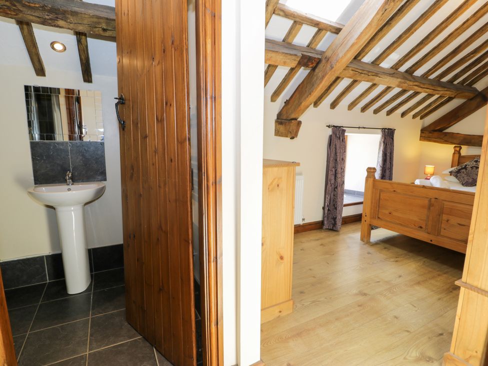 A bedroom with a bed and a sink visible at Bwthyn Y Wennol Dolwen near Abergele