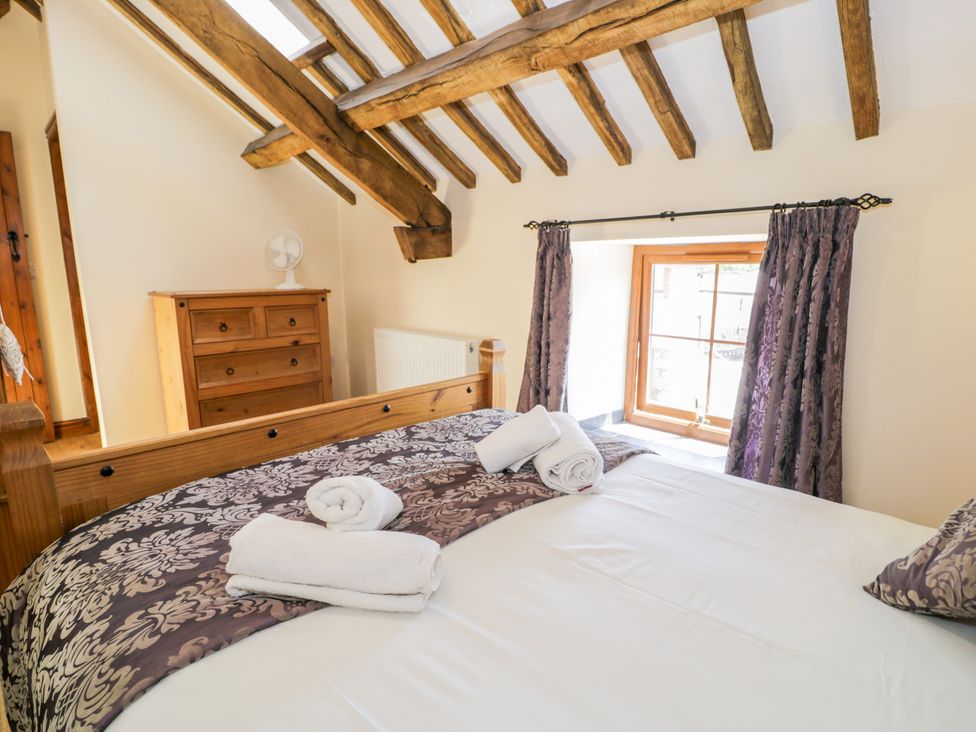 A bedroom with a bed and dresser at Bwthyn Y Wennol Dolwen near Abergele