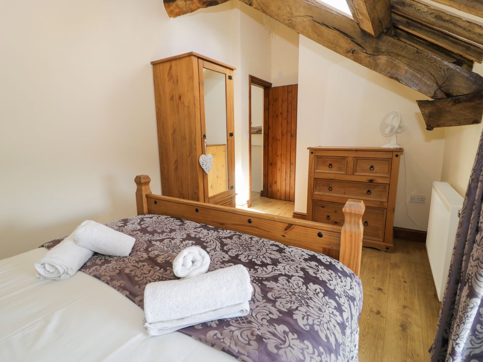 A bedroom with a wooden bed and furniture at Bwthyn Y Wennol Dolwen near Abergele