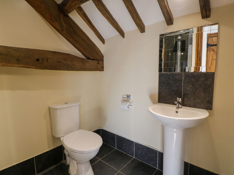 A bathroom with a toilet and sink at Bwthyn Y Wennol in Dolwen near Abergele