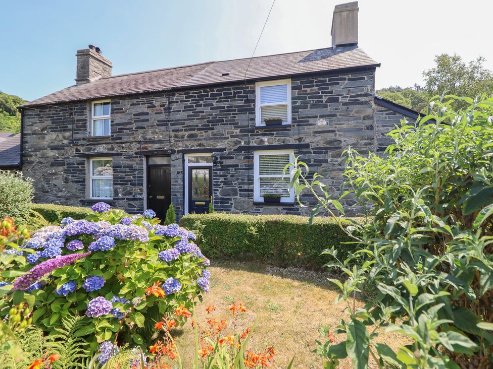 A stone house with garden flowers at Arthur’s Cottage Abergynolwyn near Tywyn
