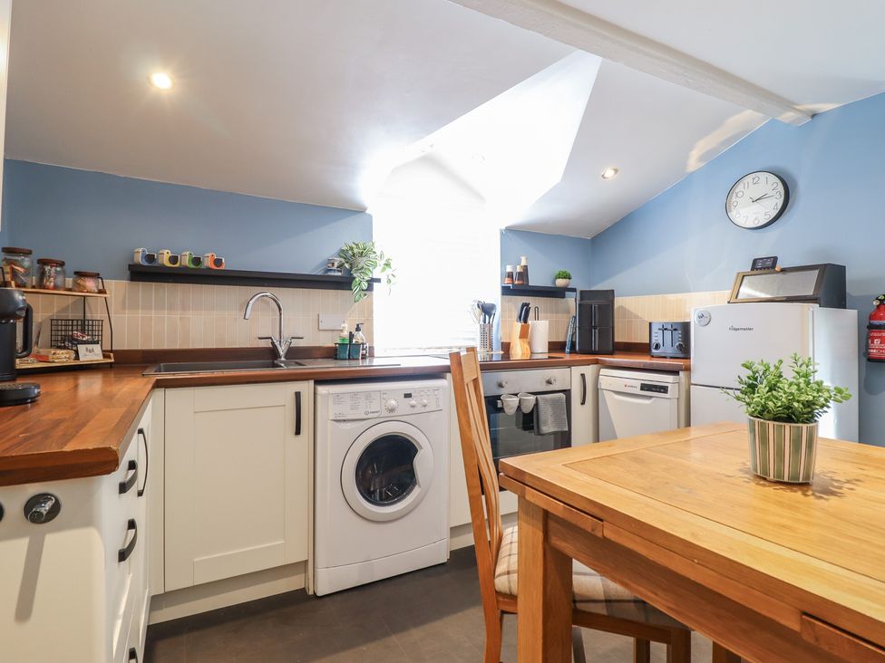 A kitchen with appliances and a dining table at Arthur’s Cottage Abergynolwyn near Tywyn