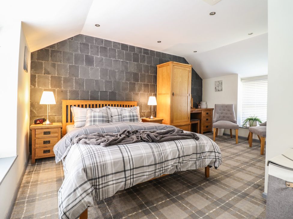 A bedroom with a bed and nightstands at Arthur’s Cottage Abergynolwyn near Tywyn