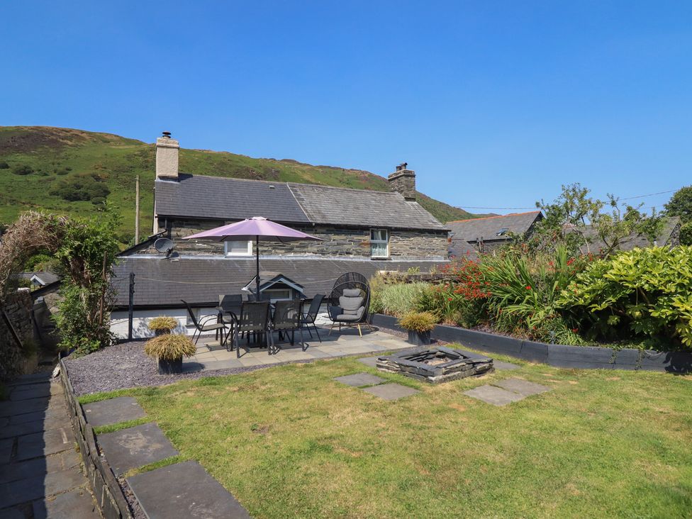 A garden with a patio table and chairs at Arthur’s Cottage Abergynolwyn near Tywyn