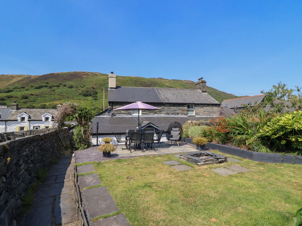 A garden with seating area and fire pit at Arthur’s Cottage Abergynolwyn near Tywyn