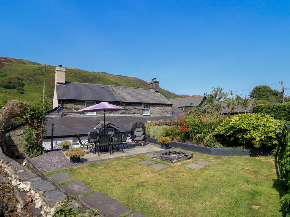 A garden with furniture and a fire pit at Arthur’s Cottage in Abergynolwyn near Tywyn