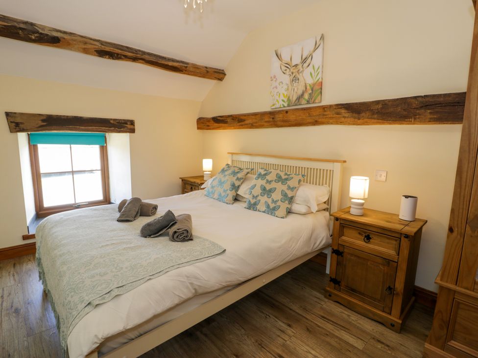 A bedroom with a bed and bedside table at Cornel Clyd, Dolwen near Abergele