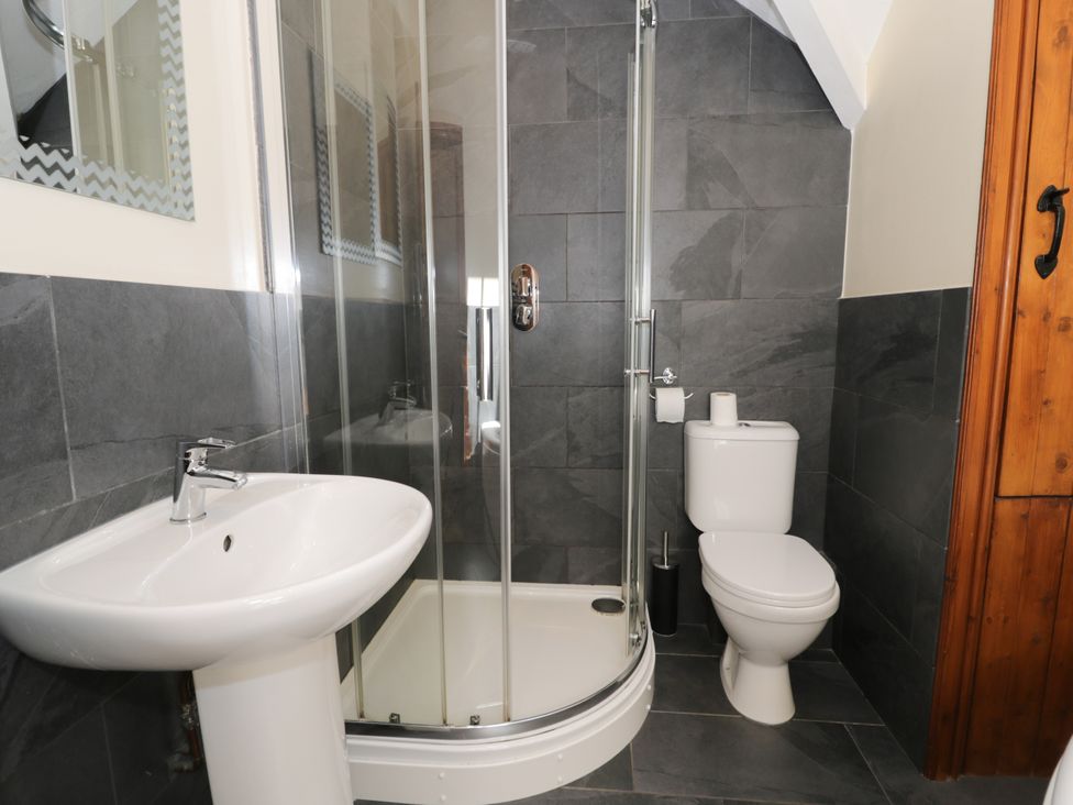 A bathroom with a sink, shower and toilet at Cornel Clyd in Dolwen near Abergele