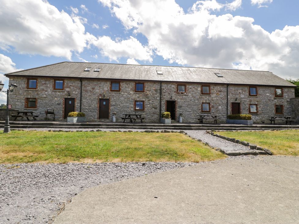 A stone building with tables and chairs at Cornel Clyd Dolwen near Abergele