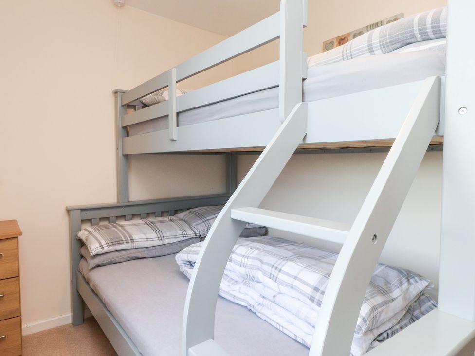 A bedroom with a bunk bed and dresser at Pant Fali Aberdaron
