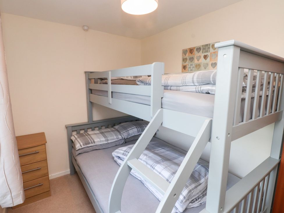 A bedroom with a bunk bed and nightstand at Pant Fali in Aberdaron