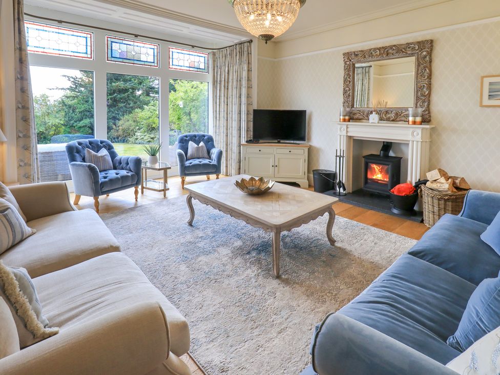 A living room with a fireplace and two armchairs at Fern Bank in Penrith