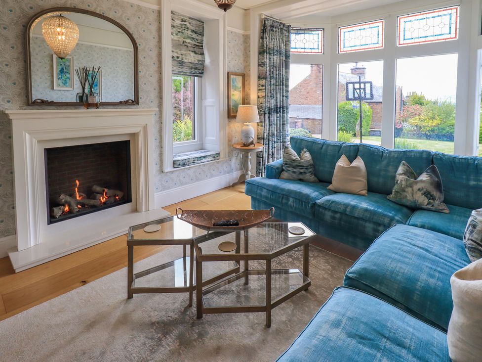 A living room with a fireplace and a sofa at Fern Bank in Penrith