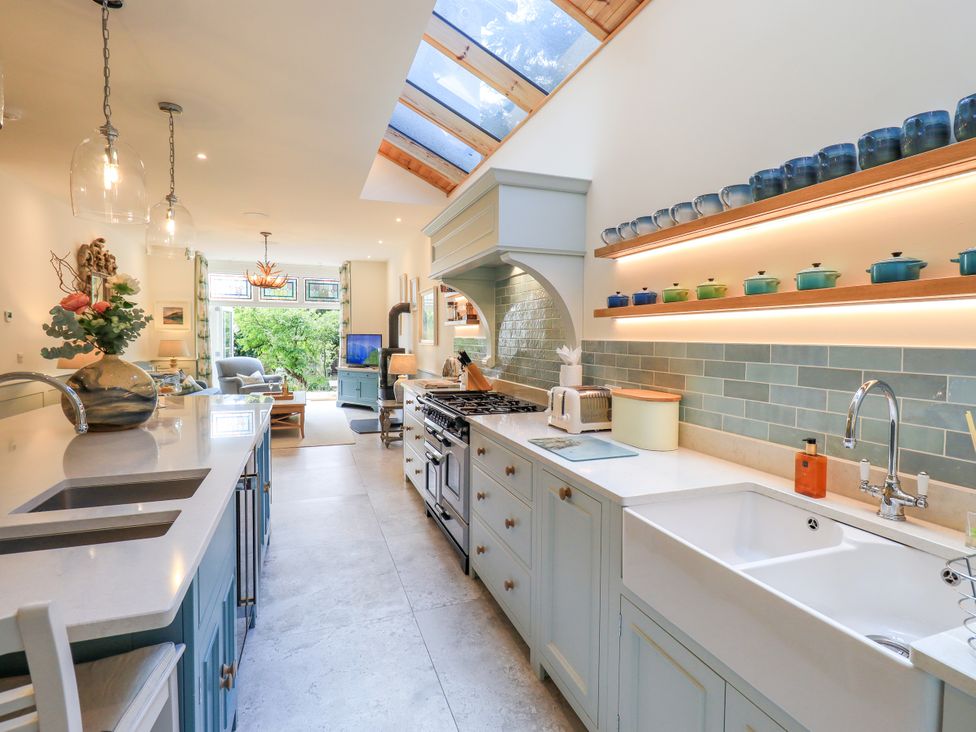A kitchen with a sink, stove, and kitchen island at Fern Bank in Penrith