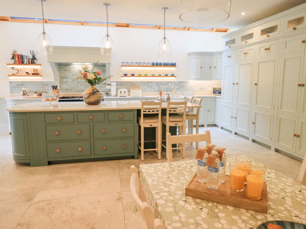 A kitchen with a modern design featuring an island and bar stools at Fern Bank Penrith