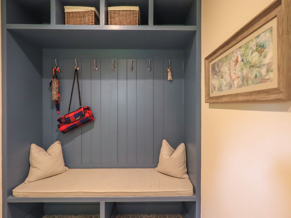 A mudroom with bench, cushion, hooks and baskets at Fern Bank in Penrith