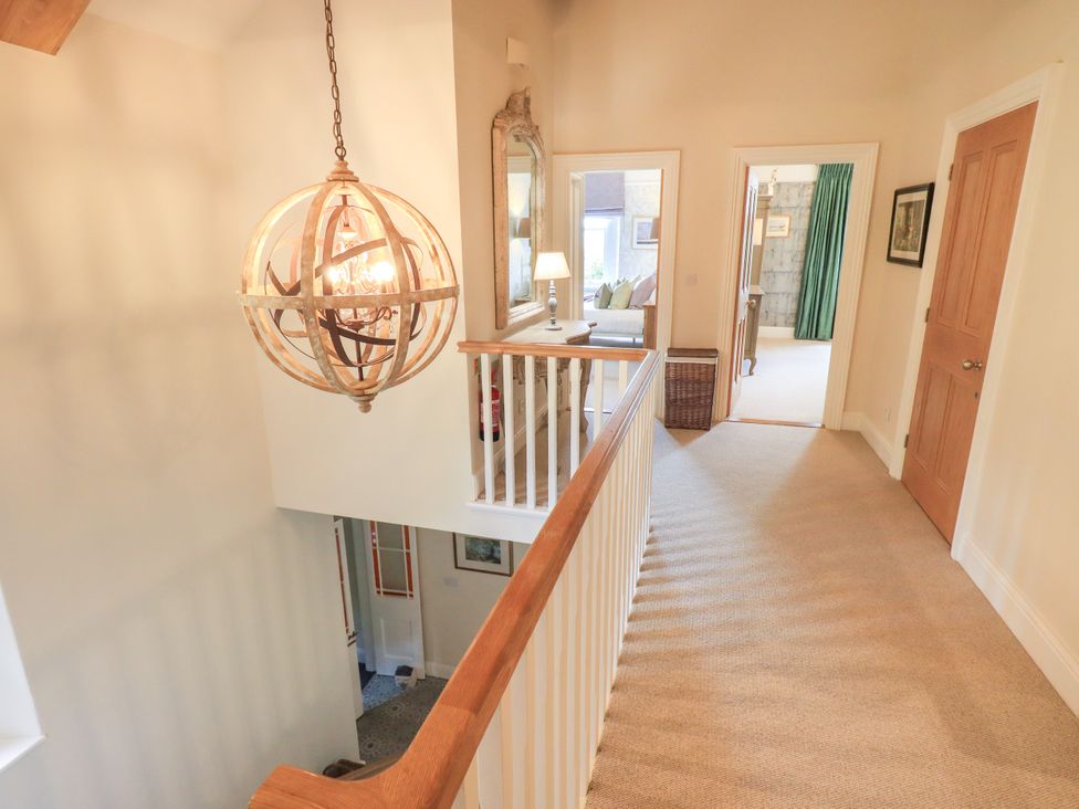 A hallway with a chandelier and doors at Fern Bank in Penrith