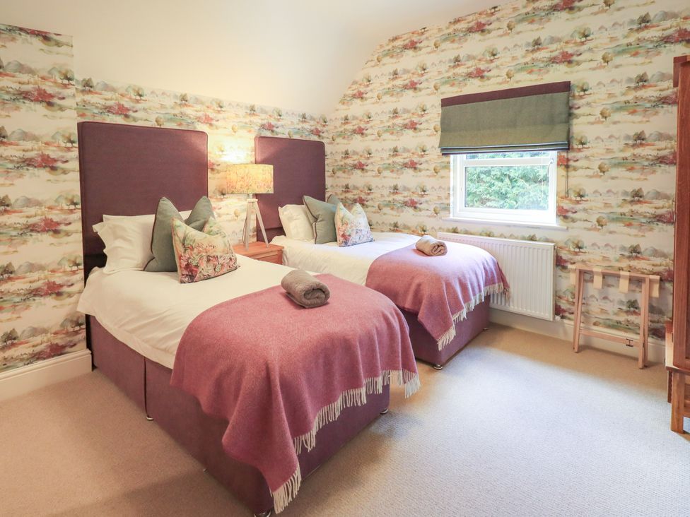 A bedroom with two single beds and a window at Fern Bank in Penrith