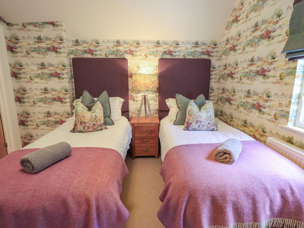 A bedroom with two beds and a nightstand at Fern Bank in Penrith