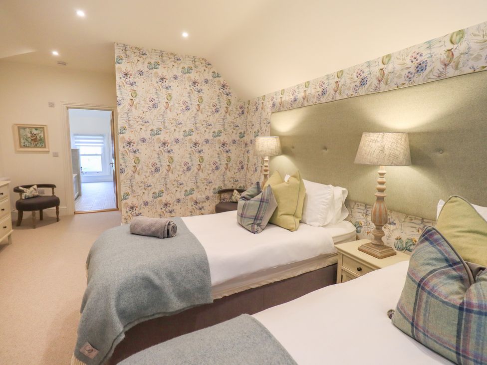 A bedroom with two beds and lamps at Fern Bank in Penrith