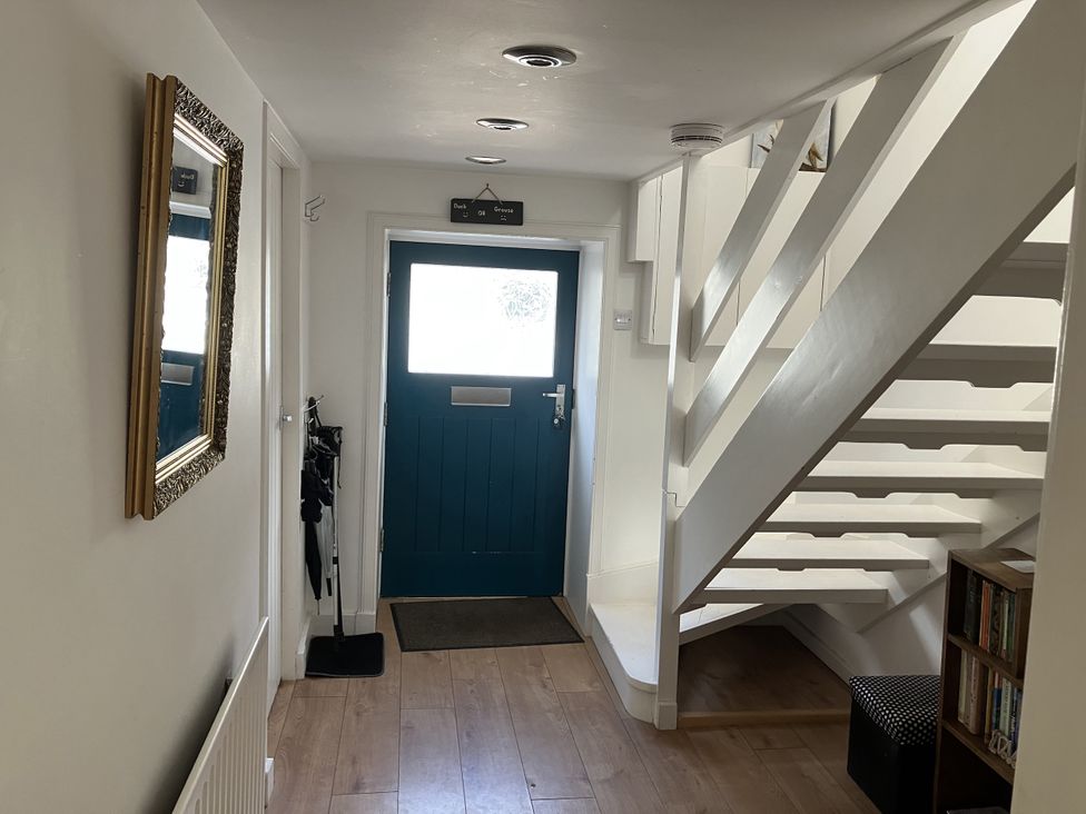 A hallway with stairs and a front door at 3 Dunrobin Street Tain