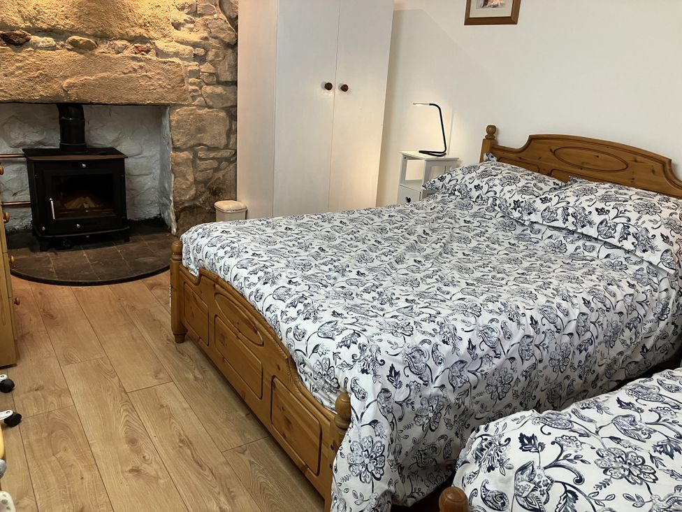 A bedroom with a bed and a fireplace at 3 Dunrobin Street Tain