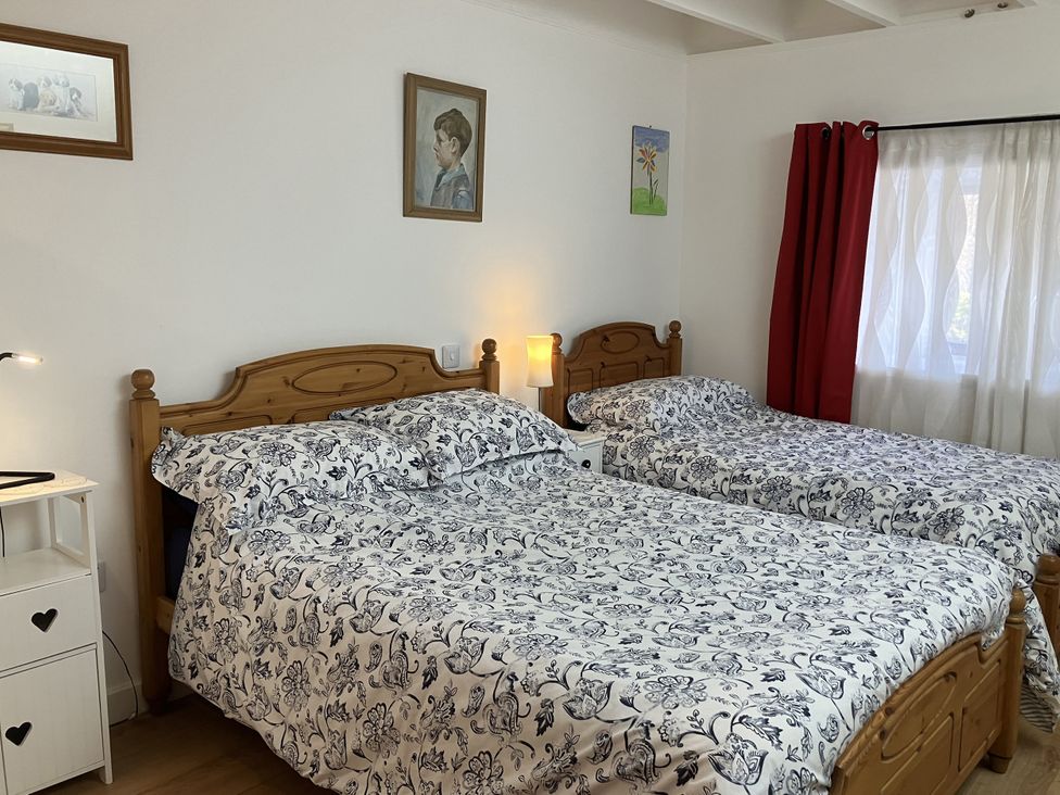 A bedroom with two beds and a nightstand at 3 Dunrobin Street, Tain