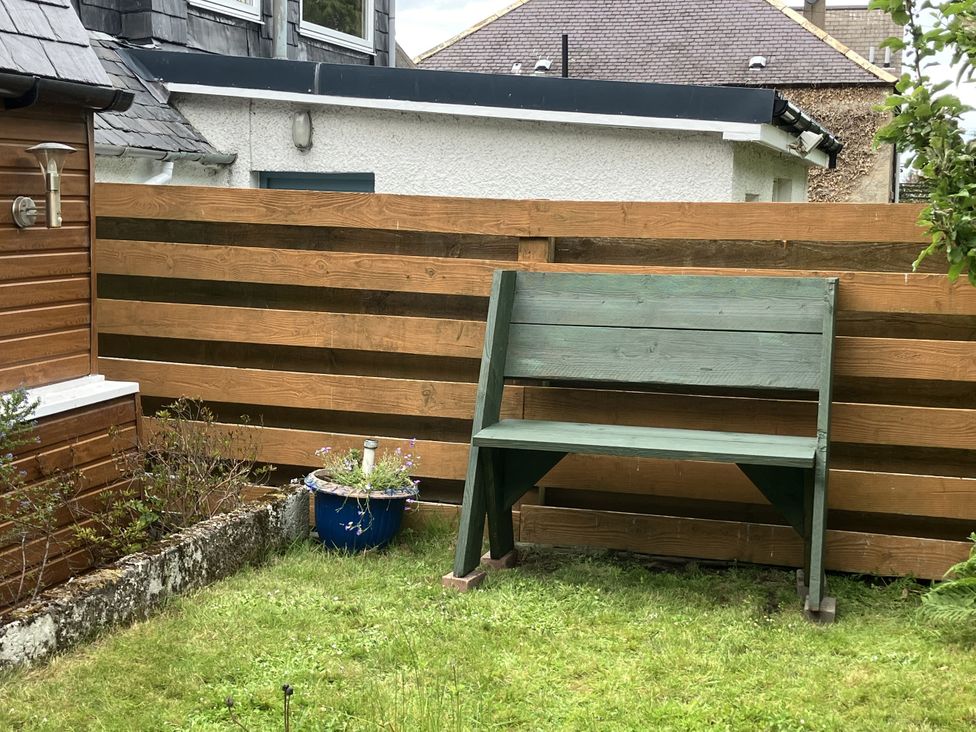 A garden with a bench and flower pot at 3 Dunrobin Street Tain
