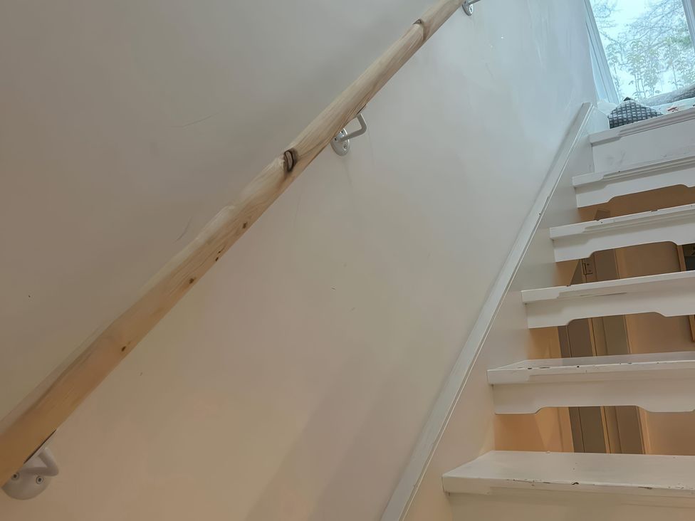 A staircase with a wooden handrail at 3 Dunrobin Street, Tain