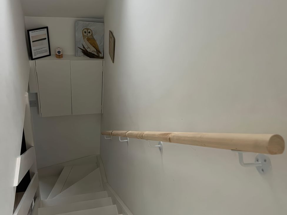 A staircase with a handrail and artwork at 3 Dunrobin Street Tain