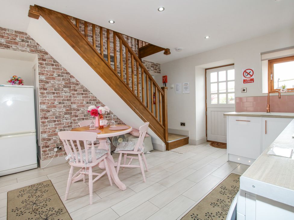 A kitchen with a table and chairs at Meadow Barn Aston On Clun