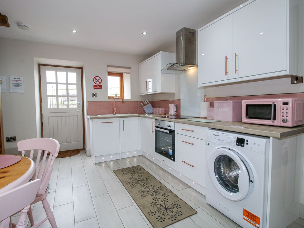 A kitchen with appliances and a table at Meadow Barn in Aston On Clun