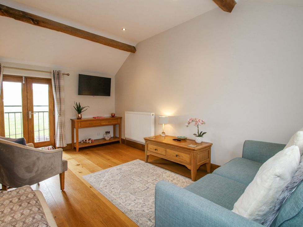 A living room with a sofa and coffee table at Meadow Barn Aston On Clun