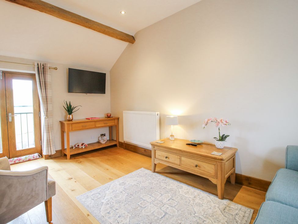 A living room with a sofa and tv at Meadow Barn in Aston On Clun