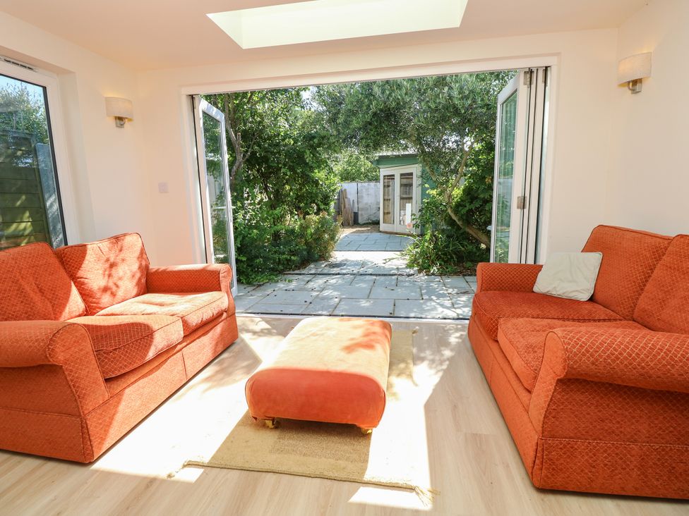 A snug with a sofa and pathway leading to garden at Merrilees Yarmouth