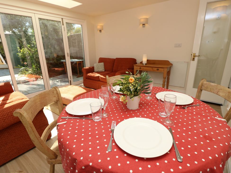 A dining area with a round table set for a meal at Merrilees in Yarmouth