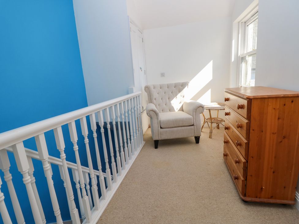 A hallway with an armchair and a chest of drawers at Merrilees in Yarmouth