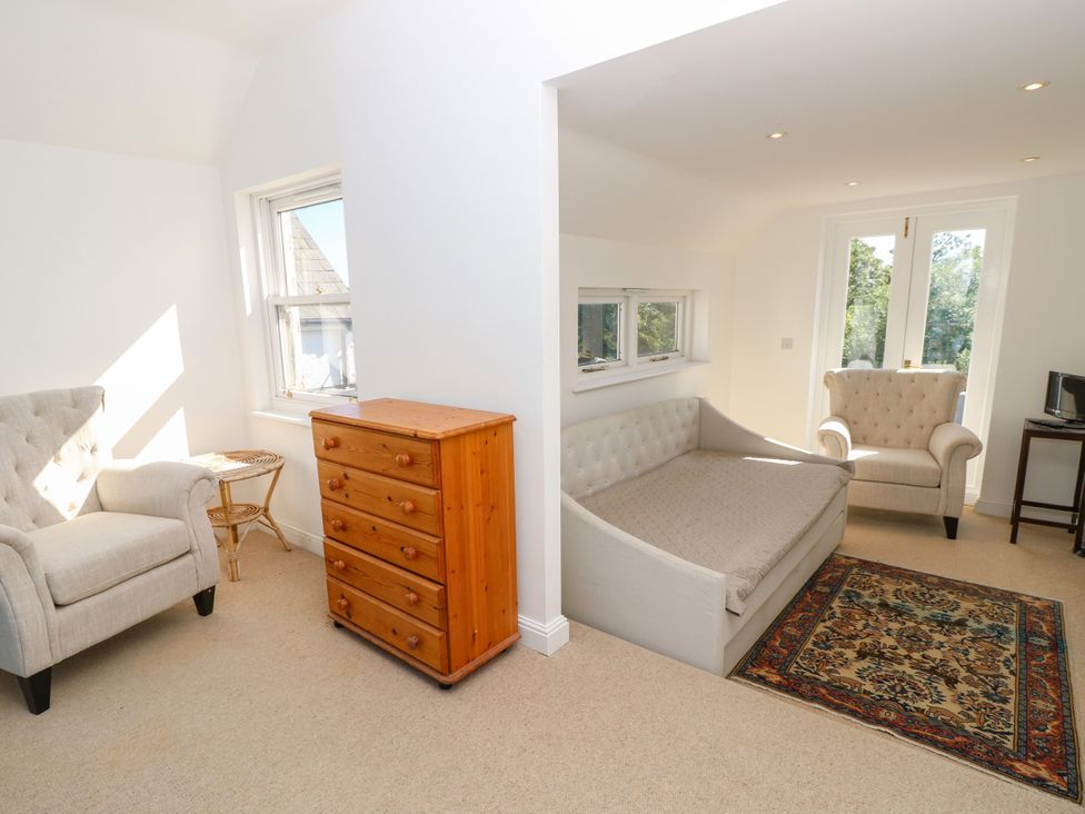 A living room with a sofa, armchairs, and dresser at Merrilees in Yarmouth