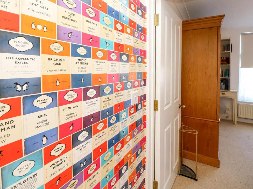 A study with a bookshelf and a wall featuring book cover designs at Merrilees in Yarmouth