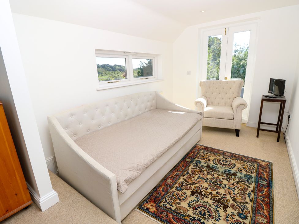 A bedroom with a sofa bed and armchair at Merrilees Yarmouth