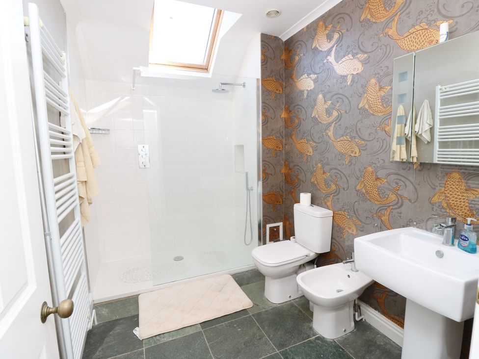 A bathroom with a shower, toilet, bidet, and sink at Merrilees in Yarmouth