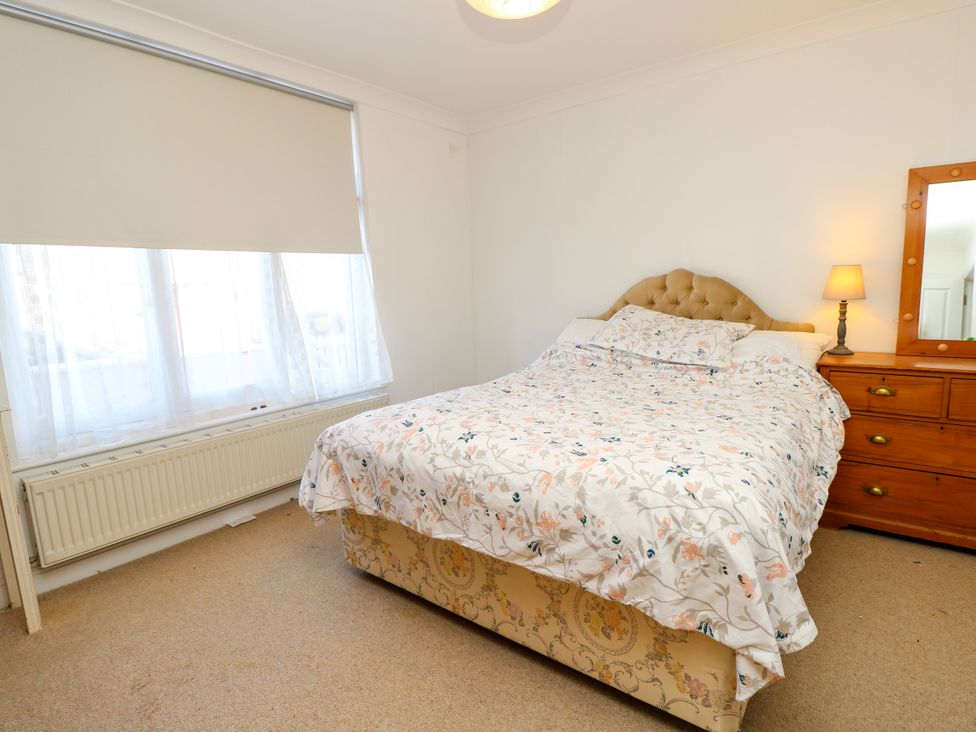 A bedroom with a bed and a dressing table at Merrilees in Yarmouth