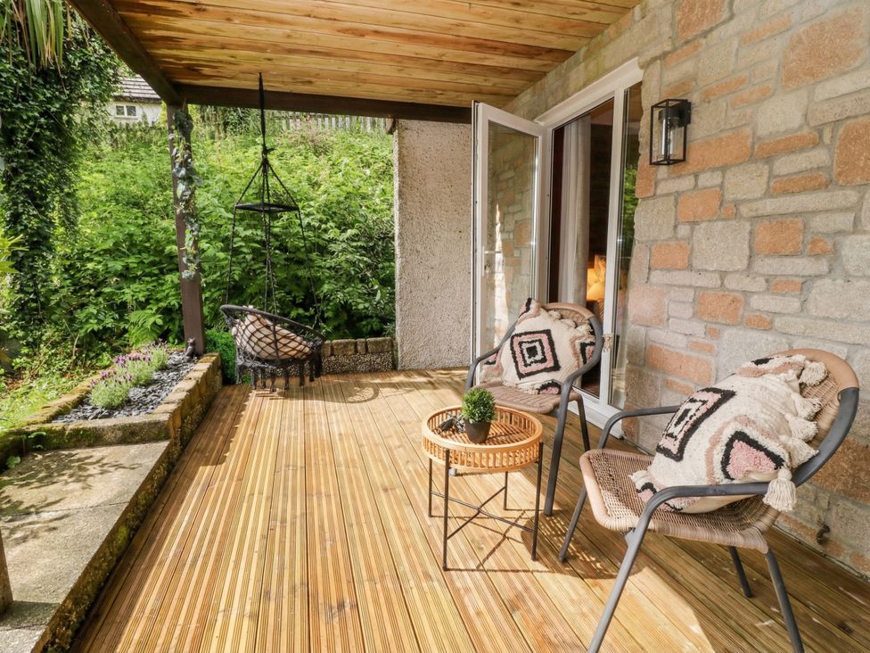 An outdoor area with hanging chair and two chairs at Lavender Lodge, St. Ann's Chapel, Cornwall