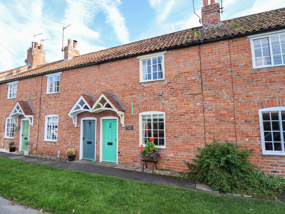 A row of brick cottages with entrance doors and windows at Marmaduke Cottage in Market Weighton