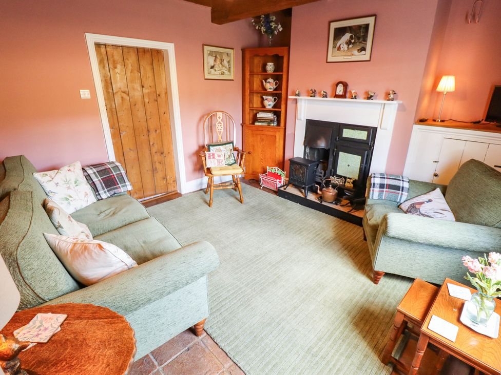 A living room with sofa and fireplace at Marmaduke Cottage in Market Weighton