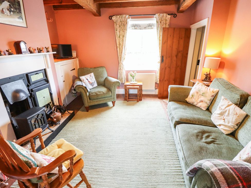 A living room with a sofa and armchair at Marmaduke Cottage in Market Weighton