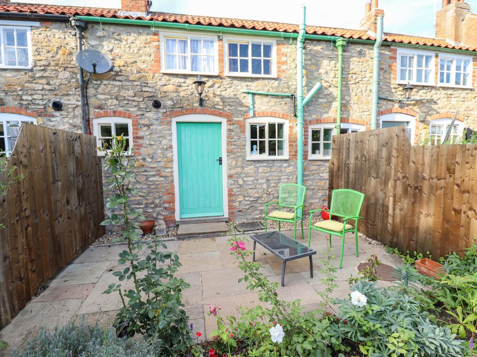 A garden with two chairs and a table at Marmaduke Cottage in Market Weighton